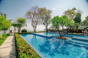 a swimming pool with a tree in the middle at Baan Sandao Condo in Hua Hin