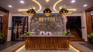 two people sitting at a bar in a hotel lobby at Araya Angkor Residence in Siem Reap