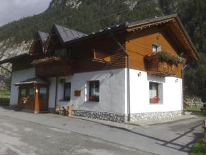 a house with flowers on the windows of it at La Vecchia Latteria in Pontebba