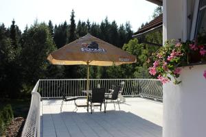 eine Terrasse mit einem Tisch und einem Sonnenschirm in der Unterkunft Pension Najdek in Saar