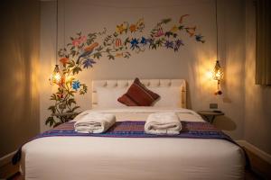 1 dormitorio con 1 cama con toallas en Home Garden Hotel, en Cusco