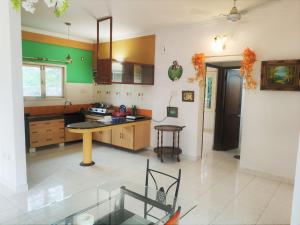 una cocina con paredes verdes y blancas y una mesa en Private Luxury Beach Side Villa, en Chennai