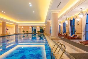 a swimming pool in a hotel with columns and a lobby at Your World International Conference Centre in Yiwu