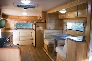 an rv with a kitchen and a table in it at Longford Riverside Caravan Park in Longford