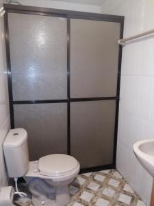 a bathroom with a toilet and a sink at Residencial Mariloy in Cochabamba