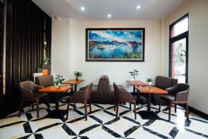 a restaurant with tables and chairs and a painting on the wall at HOÀNG LONG HOTEL in Ha Long