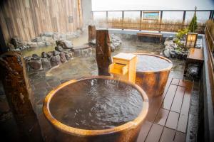 富良野La Vista Furano Hills Natural Hot Spring的室内装满水的浴缸