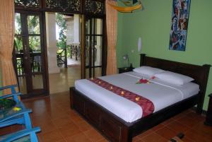 una camera da letto con un letto con lenzuola bianche e fiori di Jungle Garden Villa a Mayong