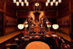uma sala de jantar com uma mesa e um relógio em 高野山 宿坊 不動院 -Koyasan Shukubo Fudoin- em Koyasan