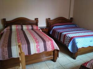 dos camas sentadas una al lado de la otra en una habitación en Residencial Mariloy, en Cochabamba