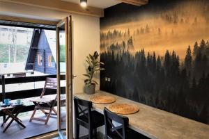 a dining room with a large painting of trees on the wall at Piękny apartament w Pieninach in Krościenko