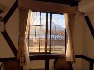 ventana en una habitación con vistas a un balcón en Pension Marieペンションマリエ, en Yamanakako