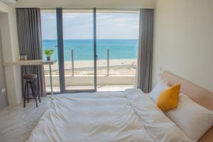 a bedroom with a bed and a view of the beach at BEACH FRONT VILLA in Baisha