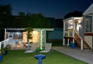 un patio trasero con sillas y una casa por la noche en Kinsellas Water Views, en Albany