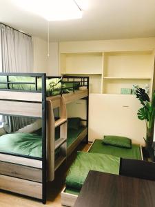 two bunk beds in a room with a table at Joinus Ise Apartment in Ise
