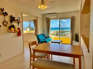 a dining room with a table and a view of the ocean at Snow ball Condominium in Kin