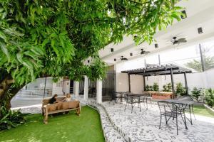 a courtyard with tables and chairs and a tree at 1075 Dormitel in Cebu City