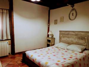 a bedroom with a bed and a clock on the wall at Ker Carlines in Targassonne
