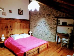 a bedroom with a bed and a brick wall at Ker Carlines in Targassonne