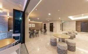 a lobby with two tables and chairs and tables and chairs at Brown Dot Hotel Deokcheon in Busan +30 photos