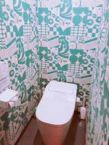 La salle de bains est pourvue de toilettes et de papier peint vert et blanc. dans l'établissement 中川西 地下鉄今里駅一戸建 Samurai House Guest House Imazato 難波直通 最大7名, à Osaka 47 autres photos