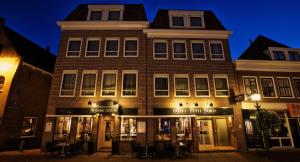 a building on a street at night at Hotel Petit Nord in Hoorn