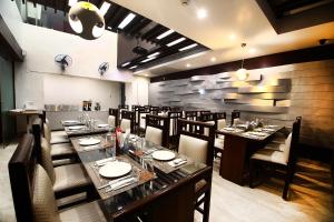 uma sala de jantar com mesas longas e cadeiras em Hotel Emerald em Chandīgarh