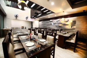 ein Esszimmer mit langen Tischen und Stühlen in der Unterkunft Hotel Emerald in Chandīgarh