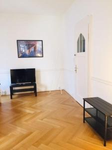 a living room with a wooden floor and a piano at Apartment Marktplatz in Basel