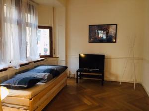 Schlafzimmer mit einem Bett, einem Schreibtisch und einem TV in der Unterkunft Apartment Marktplatz in Basel