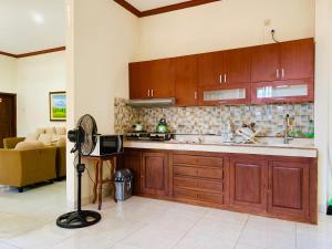 a kitchen with wooden cabinets and a tv in a room at Villa Cabean Salatiga in Salatiga