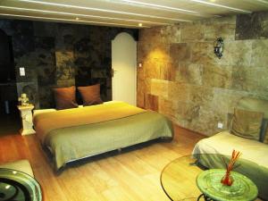 a bedroom with two beds and a table in a room at Chambres d'Hôte Dijon Clair de Lune in Chenôve