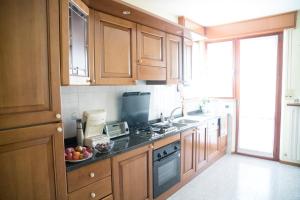 a kitchen with wooden cabinets and a bowl of fruit on the counter at Villa di agricoltori in San Costanzo