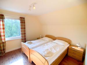 a bedroom with a bed with white sheets and a window at Am Hut in Neukirchen