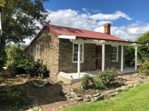 una pequeña casa de ladrillo con techo rojo en Dalton's Deed en Roxburgh