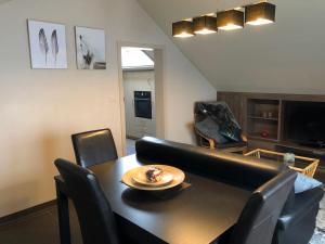 Gastenverblijf 't Princenhuis في Vechmaal: غرفة معيشة مع طاولة سوداء وكراسي