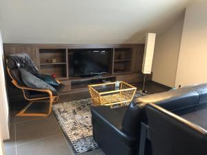 ein Wohnzimmer mit einem Sofa und einem TV in der Unterkunft Gastenverblijf 't Princenhuis in Vechmaal