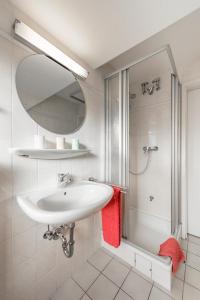 a white bathroom with a sink and a shower at Haus Dünenglück Whg. 34 in Cuxhaven