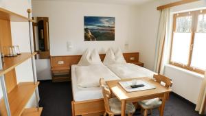 a hotel room with a bed and a table at Haus Holzer in Wagrain