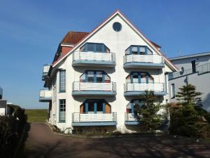 un edificio blanco con balcones en un lateral en Haus Dünenglück Whg. 34, en Cuxhaven