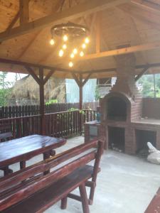 a pavilion with a picnic table and a brick oven at Vila Chiojdu in Chiojdu