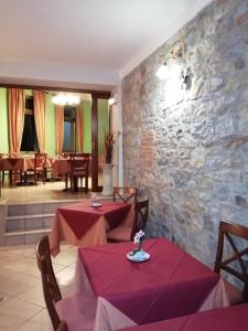 a restaurant with two tables and a stone wall at Hotel Azzurra in Salsomaggiore Terme