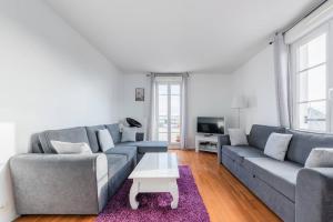 Sala de estar con 2 sofás y mesa de centro en Smart apartment Val d'Europe 7/9 pers, en Chessy