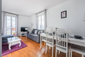 uma sala de estar com uma mesa e um sofá em Smart apartment Val d'Europe 7/9 pers em Chessy