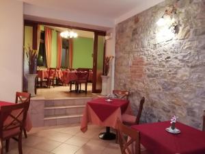 a restaurant with red tables and a stone wall at Hotel Azzurra in Salsomaggiore Terme