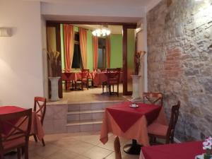 un restaurant avec des tables et des chaises rouges dans une salle dans l'établissement Hotel Azzurra, à Salsomaggiore Terme