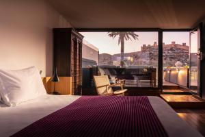 1 dormitorio con cama y vistas a la ciudad en Aire Hotel & Ancient Baths, en Almería