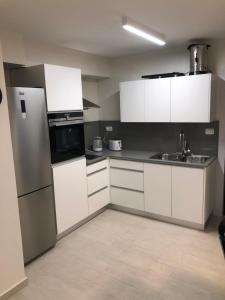 a kitchen with white cabinets and a stainless steel refrigerator at Buchman apartment near center in Modi‘in