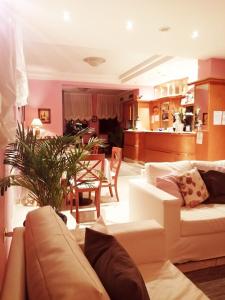 - un salon avec un canapé et une salle à manger dans l'établissement Hotel Azzurra, à Salsomaggiore Terme