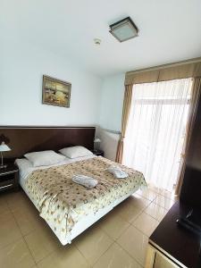 ein Schlafzimmer mit einem Bett und einem großen Fenster in der Unterkunft Diune Apart by Villmaris in Kołobrzeg